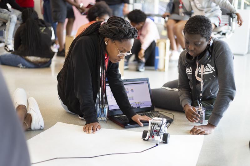 Students work to program a robot during a summer course