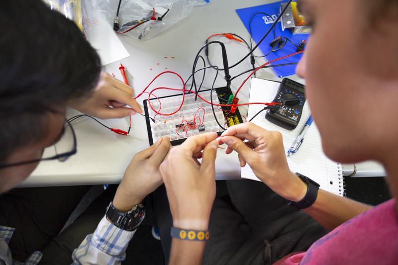 Students work on a circuitboard in an electrical engineering class.